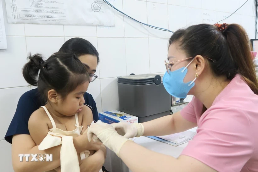 Nhân viên trạm Y tế Phường 6, Quận 8 tiêm vaccine phòng sởi cho trẻ. Ảnh: Đinh Hằng/TTXVN.