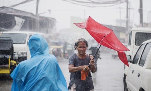 Một cư dân tại Manila, Philippines, đi giữa cơn mưa lớn khi siêu bão Mangkhut đổ bộ ngày 15/9. 