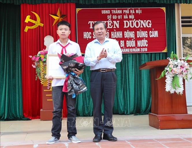 Phó Giám đốc Sở Giáo dục và Đào tạo Hà Nội Lê Ngọc Quang trao Bằng khen của Chủ tịch UBND thành phố Hà Nội cho em Phan Trung Hiếu. Ảnh: Thanh Tùng/TTXVN