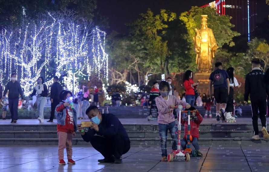 Người dân vui chơi đón năm mới tại khu vực Tượng đài Lý Thái Tổ. (Ảnh: Hoàng Hiếu/TTXVN)