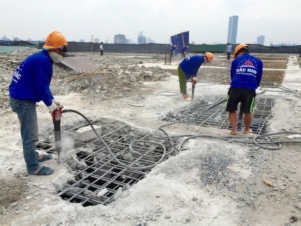 Công ty cổ phần Phương Bắc dùng máy khoan phá dỡ bêtông tòa nhà 8B Lê Trực. (Ảnh: Minh Nghĩa/TTXVN)