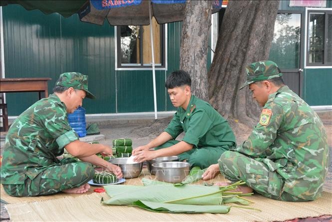 Các chiến sĩ biên phòng tại Chốt kiểm soát biên giới, Đồn Biên phòng Ia Rvê, Bộ đội Biên phòng Đắk Lắk gói bánh chưng cùng nhau đón Tết nơi biên cương. Ảnh: TTXVN.