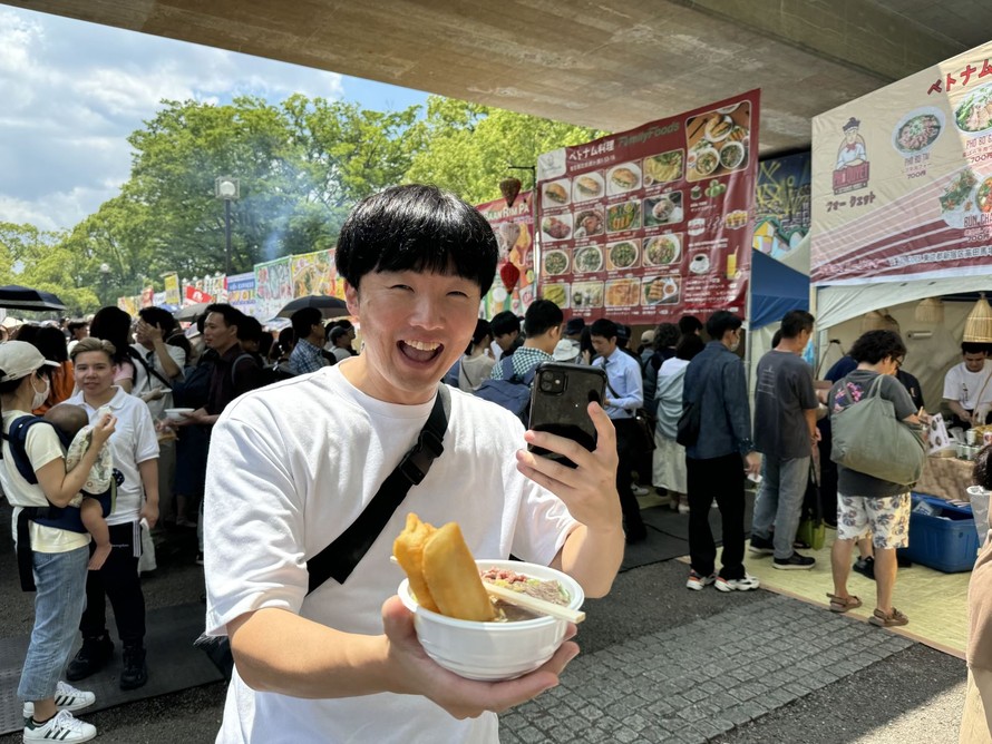 Một thanh niên Nhật Bản vui mừng khi mua được một tô phở mà anh nói rằng đúng hương vị phở Hà Nội. Ảnh: Phạm Tuân