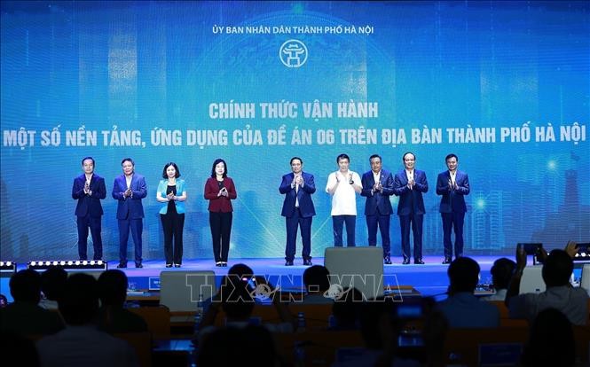 Thủ tướng Phạm Minh Chính và các đại biểu thực hiện nghi thức vận hành các nền tảng, ứng dụng của Đề án 06. Ảnh: Dương Giang
