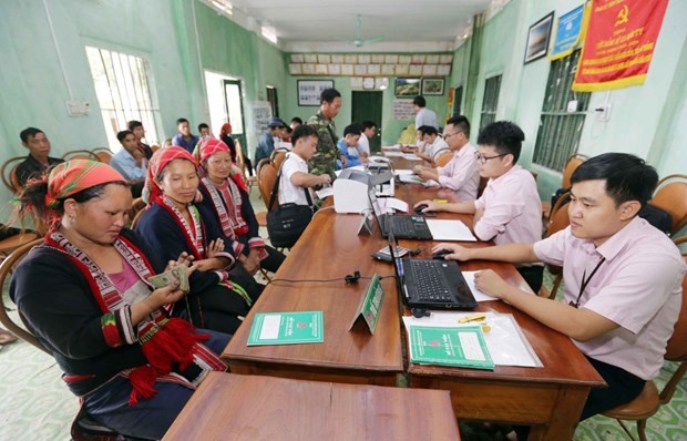 Bà con làm thủ tục vay vốn với cán bộ Ngân hàng Chính sách Xã hội. (Ảnh: CTV/Vietnam+)