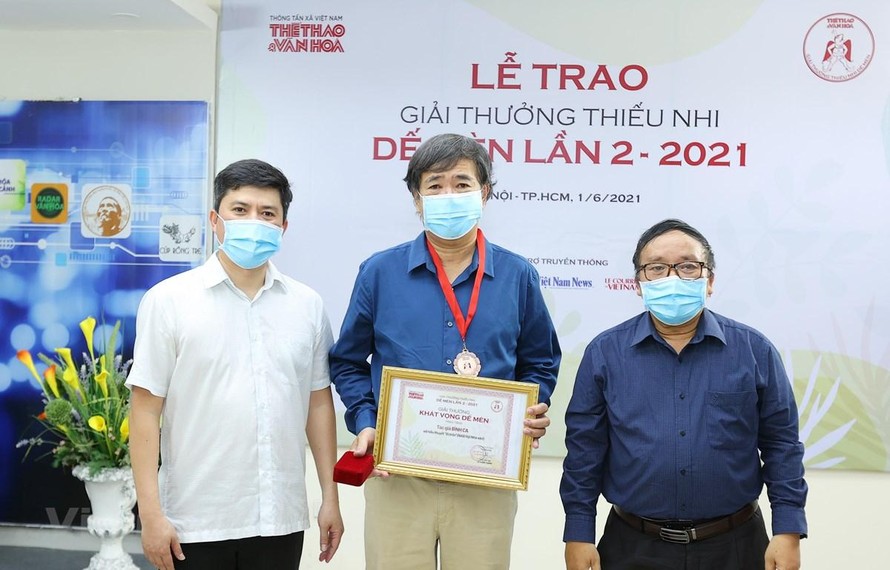 Ông Lê Xuân Thành, Trưởng Ban tổ chức Giải (trái) và nhà thơ Trần Đăng Khoa, Chủ tịch Hội đồng giám khảo (phải) trao giải cho tác giả Bình Ca (giữa). (Ảnh: Hòa Nguyễn/Vietnam+)