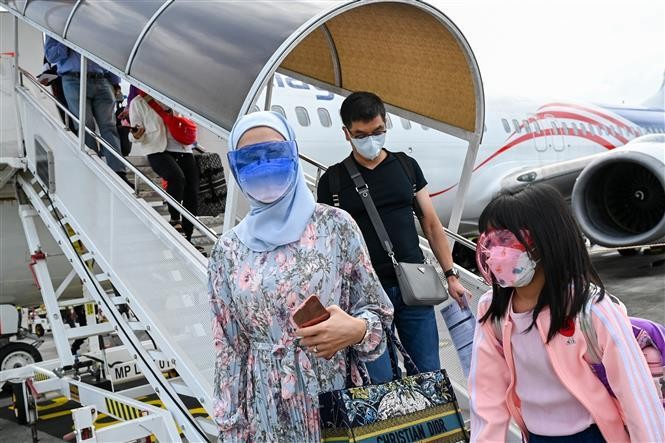 Hành khách đeo khẩu trang phòng lây nhiễm COVID-19 tại sân bay ở Langkawi, Malaysia, ngày 16/9/2021. Ảnh: AFP/TTXVN