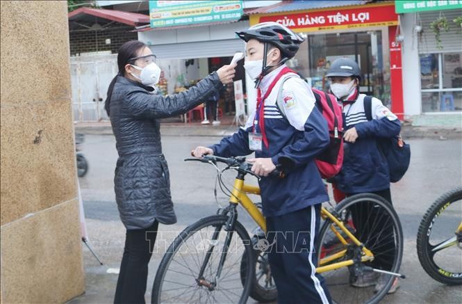 Đo thân nhiệt cho học sinh Trường THCS Nguyễn Du, thành phố Thái Nguyên trước khi vào lớp. Ảnh minh họa: Hoàng Nguyên/TTXVN