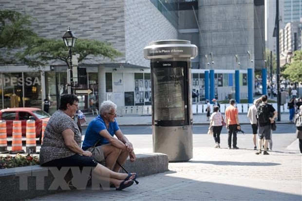 Người dân tránh nắng dưới bóng râm tại Montreal, Quebec, Canada. (Ảnh: AFP/TTXVN)