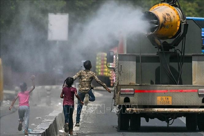 Phun nước hạ nhiệt trên đường phố trong ngày nắng nóng tại New Delhi, Ấn Độ, ngày 28/5/2024. Ảnh: AFP/TTXVN