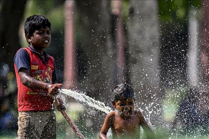 Trẻ em chơi đùa với nước trong ngày nắng nóng tại New Delhi, Ấn Độ, ngày 31/5/2024. Ảnh: AFP/TTXVN