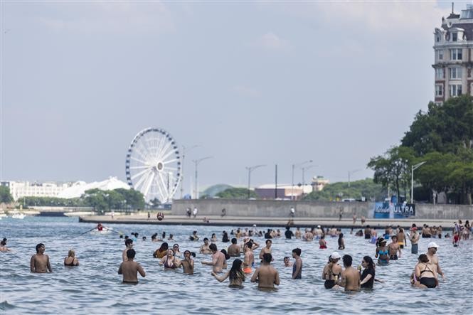 Người dân tắm giải nhiệt trong ngày nắng nóng tại hồ Michigan, Chicago, Mỹ, ngày 17/6/2024. Ảnh: THX/TTXVN