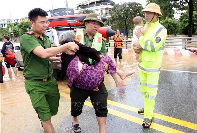 Lực lượng cứu hộ, cứu nạn nỗ lực đưa người từ tâm lũ ra ngoài. Ảnh: Trần Trang/TTXVN