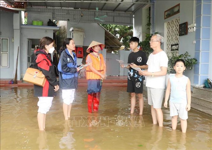 Cán bộ y tế cơ sở tuyên truyền vệ sinh môi trường cho người dân vùng ngập lụt xã Gia Thủy, huyện Nho Quan, tỉnh Ninh Bình.