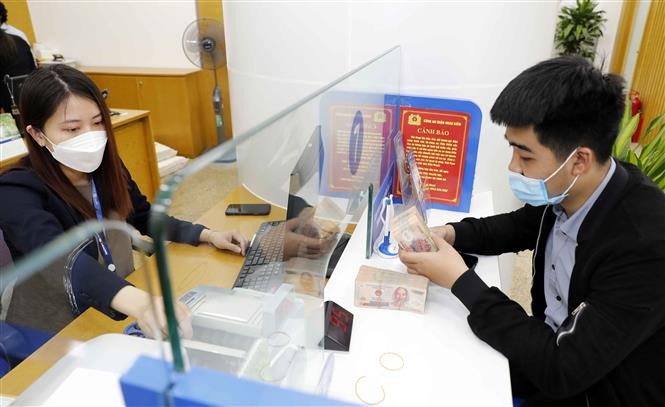 Khách hàng giao dịch vay vốn tại Ngân hàng TMCP Bảo Việt. Ảnh: Trần Việt /TTXVN