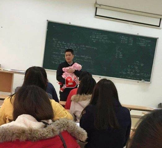 Thầy giáo bế con cho nữ sinh viên làm bài thi thu hút sự chú ý của cộng đồng mạng. Ảnh: beat.vn