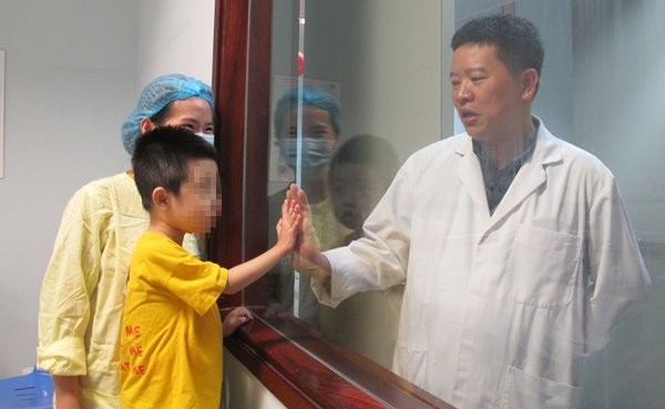 Bé Dũng chơi đùa với bác sĩ trước giờ xuất viện