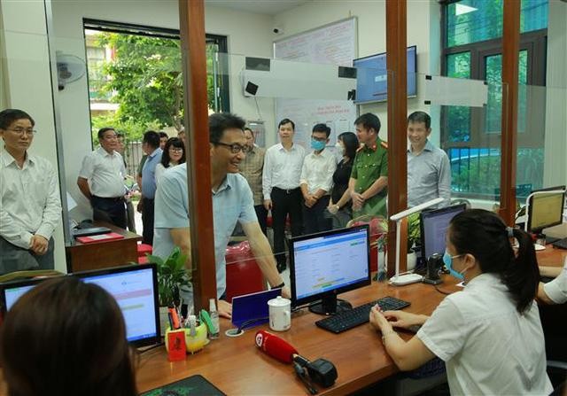 Phó Thủ tướng Vũ Đức Đam kiểm tra việc triển khai Đề án 06 tại UBND phường Hàng Bài. Ảnh: TTXVN