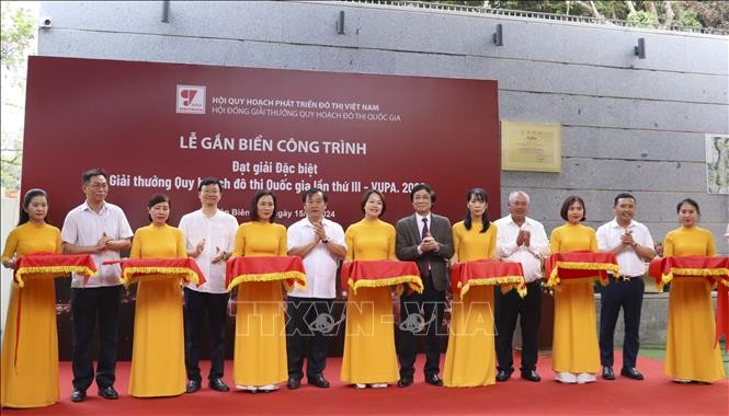 Các đại biểu cắt băng khánh thành tại lễ gắn biển công trình đạt giải Đặc biệt giải thưởng Quy hoạch đô thị Quốc gia lần thứ III đối với Đền thờ Liệt sĩ Chiến trường Điện Biên Phủ. 