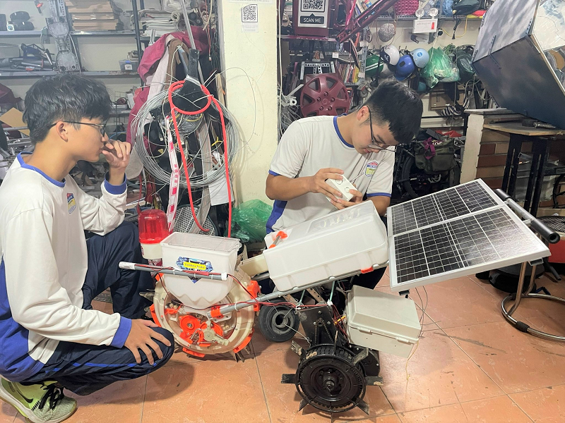 Hai em Phạm Nhật Long và Nguyễn Hoàng Ngọc Thạch, học sinh Trường THPT Chuyên Chu Văn An đang hoàn thiện mô hình máy gieo hạt bán tự động sử dụng năng lượng mặt trời, sản phẩm sáng tạo nhằm hỗ trợ nông dân giảm sức lao động và ứng dụng công nghệ vào sản xuất nông nghiệp