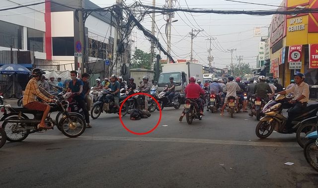Người đàn ông (khoanh tròn đỏ) nằm ngủ giữa đường bất chấp nguy hiểm