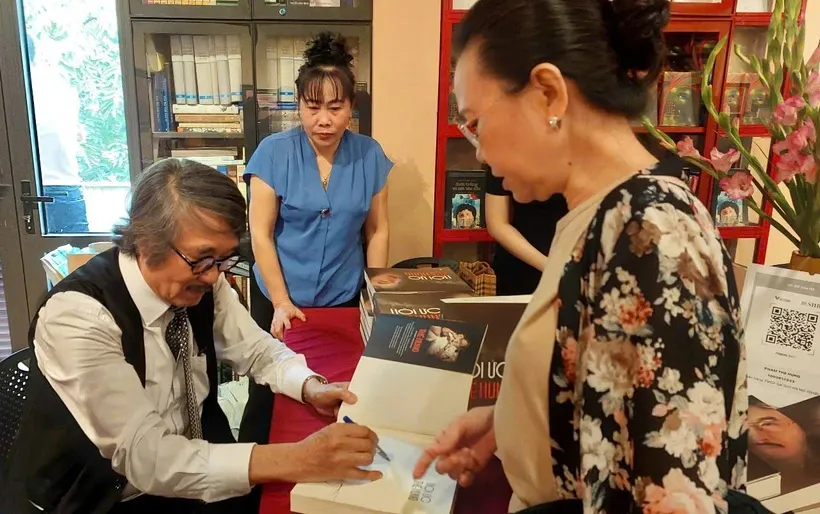 Tiến sỹ Nguyễn Thế Hùng ký tặng sách cho độc giả. Ảnh: Minh Thu/Vietnam+