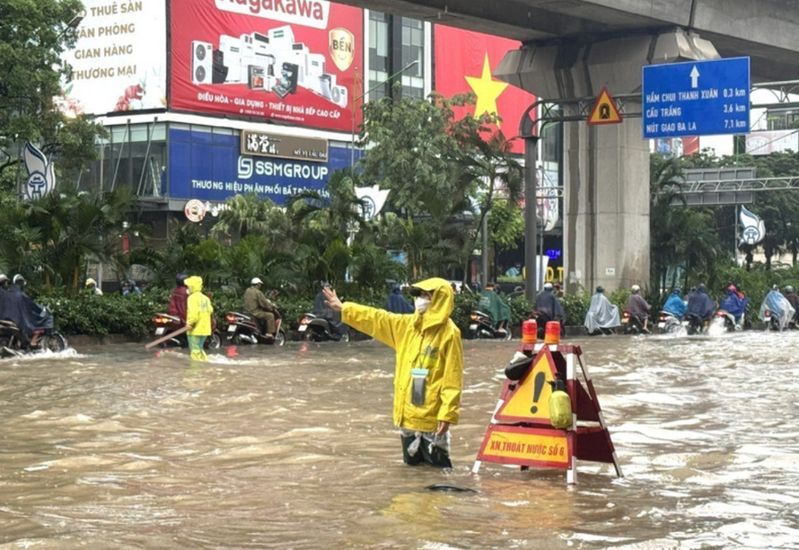 Công nhân làm nhiệm vụ thoát nước tại khu vực ngập sâu trên đường Nguyễn Trãi (Hà Nội)
