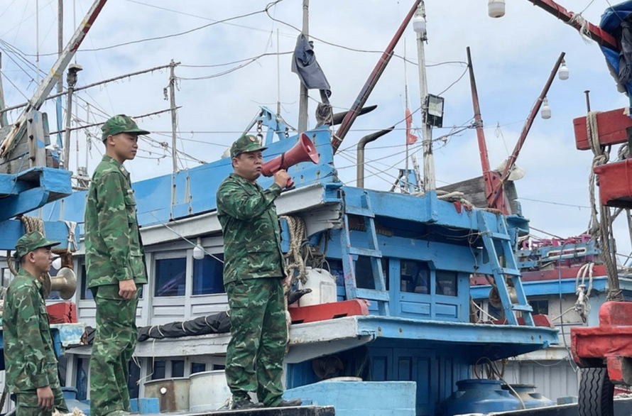 Bộ đội biên phòng dùng loa phóng thanh kêu gọi các tàu cá sắp xếp neo đậu an toàn tại cảng cá Sa Huỳnh.