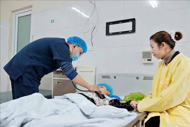 Bác sĩ thăm khám cho bệnh nhi mắc cúm A đang điều trị tại Khoa Nhi, Bệnh viện Bệnh nhiệt đới Trung ương. Ảnh: Minh Quyết/TTXVN