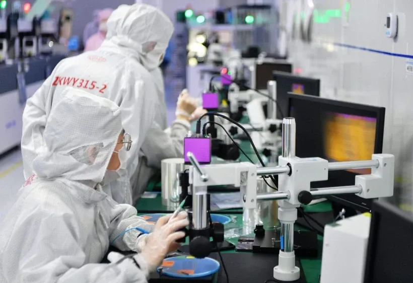 Các kỹ thuật viên làm việc trong xưởng sản xuất chip. Nguồn: Xinhua