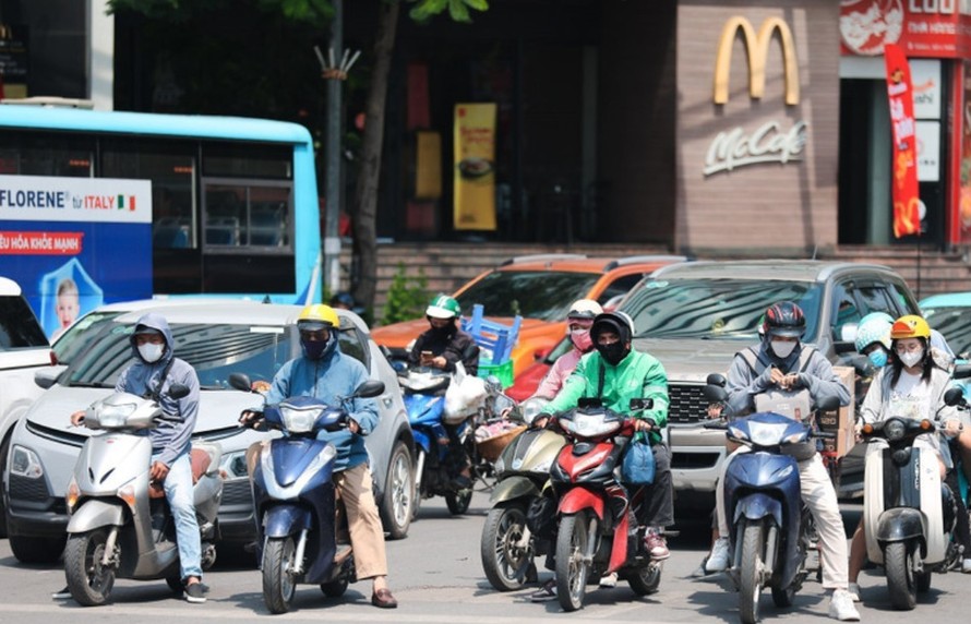 Khẩu trang, áo chống nắng là những thứ không thể thiếu cảu người dân ở Hà Nội khi tham gia giao thông trong những ngày nắng nóng. Ảnh: Lê Đông