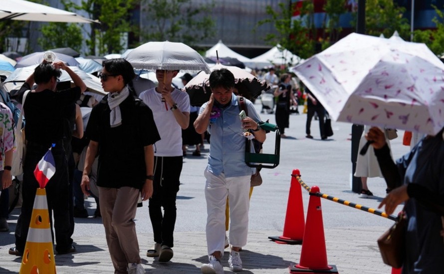 Người đi đường sử dụng ô che nắng tại Osaka, Nhật Bản.