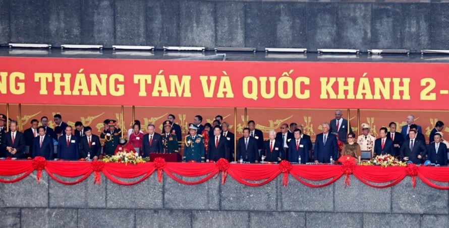 Các đồng chí lãnh đạo, nguyên lãnh đạo Đảng, Nhà nước, các vị khách quốc tế và các đại biểu thực hiện nghi lễ chào cờ. Ảnh: Doãn Tấn