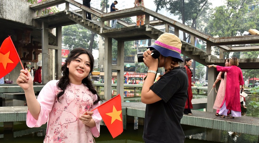 Bạn My My và Kiều Oanh chọn góc ảnh và ghi lại khoảnh khắc ngày cuối năm tại Hồ Con Rùa.. Ảnh: GIẢN THANH SƠN