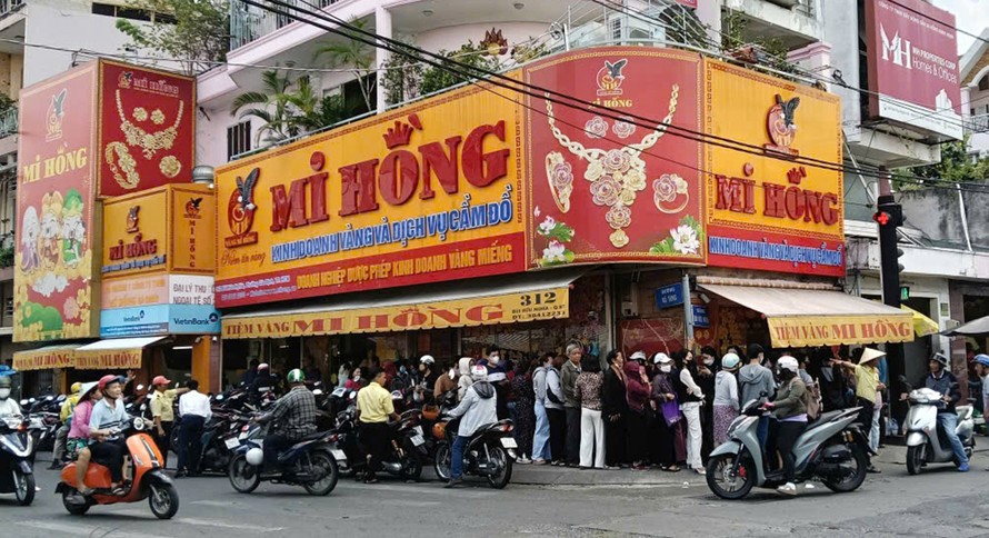 Người dân xếp hàng mua vàng trước tiệm vàng Mi Hồng. 