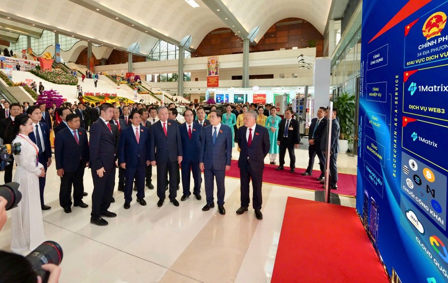 Tổng Bí thư Tô Lâm thăm khu vực trưng bày và nghe ông Phan Đức Trung chia sẻ về Mạng Dịch vụ Đa chuỗi Blockchain Việt Nam (VBSN). 