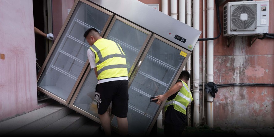 Công nhân di chuyển tủ đông ra khỏi một nhà hàng trong khu dân cư ở Thượng Hải, ngày 1/8/2022. Ảnh: Sixth Tone.