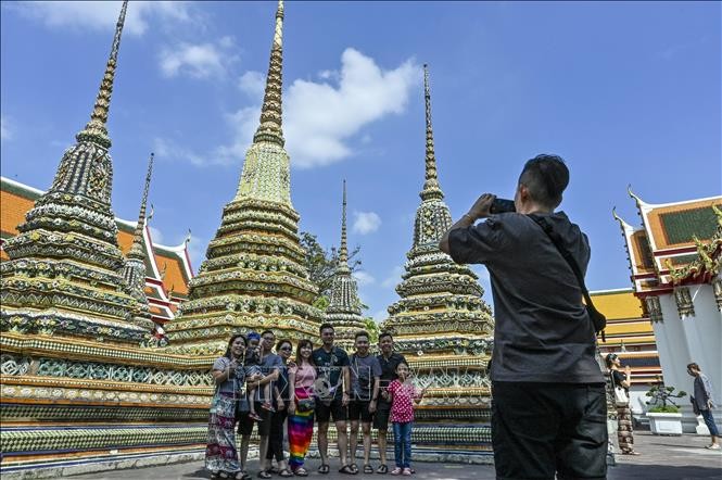 Khách du lịch chụp ảnh tại chùa Wat Pho ở thủ đô Bangkok. Ảnh: AFP/TTXVN.