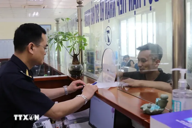 Công chức Chi cục Hải quan cửa khẩu Chi Ma hướng dẫn doanh nghiệp làm thủ tục xuất nhập khẩu hàng hóa. Ảnh: Quang Duy/TTXVN.