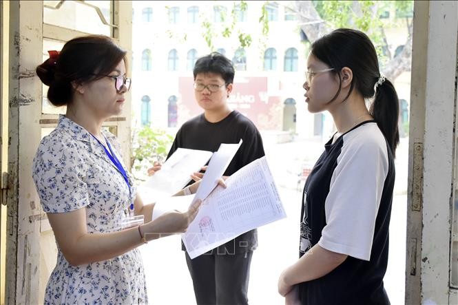 Giám thị gọi thí sinh vào phòng thi tại điểm thi Trường THPT Việt Đức (quận Hoàn Kiếm). Ảnh tư liệu: Nguyễn Cúc/TTXVN.