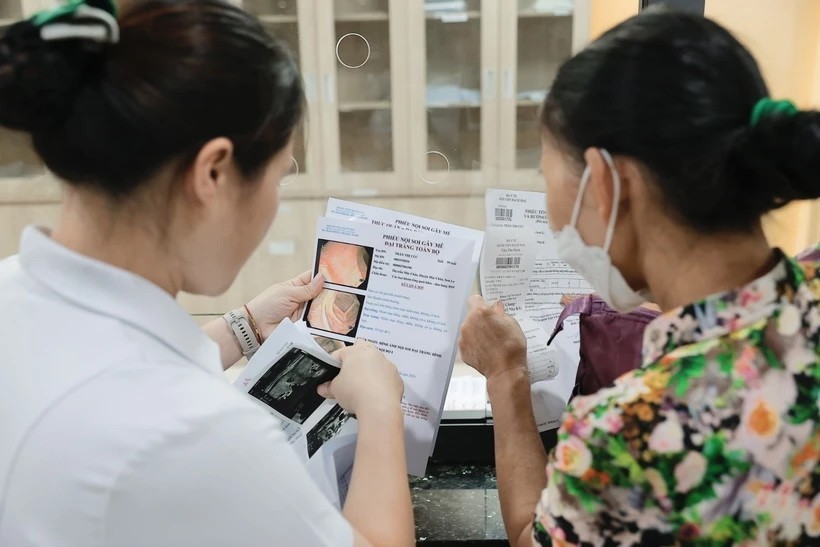 Nhân viên y tế tư vấn cho người bệnh. Ảnh: Minh Quyết/TTXVN.