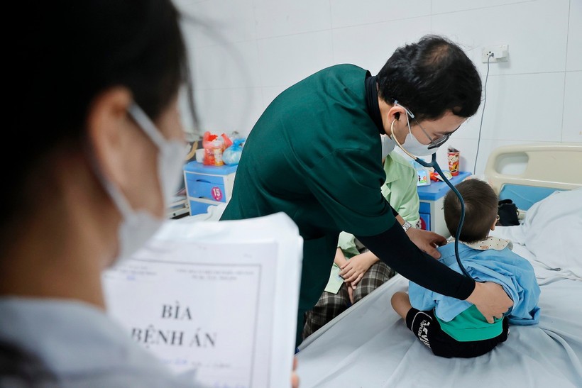 Bác sỹ khám cho bệnh nhi đang điều trị tại bệnh viện Thanh Nhàn. Ảnh: Minh Quyết/TTXVN.