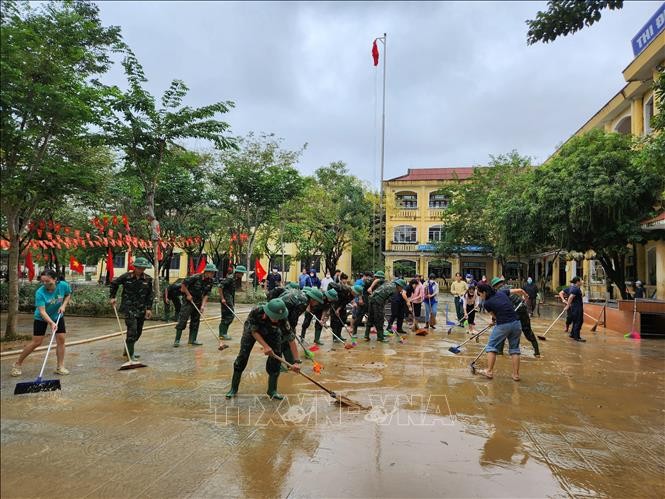 Các chiến sĩ Trung đoàn 6, Bộ Chỉ huy Quân sự thành phố Huế hỗ trợ nhân dân dọn dẹp vệ sinh sau mưa lũ. Ảnh: Mai Trang/TTXVN.