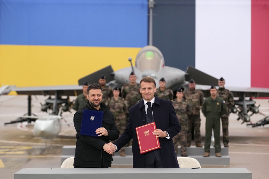 Tổng thống Pháp Emmanuel Macron (phải) và Tổng thống Ukraine Volodymyr Zelensky trao đổi thoả thuận quốc phòng ngày 17/11. Ảnh: CNN.