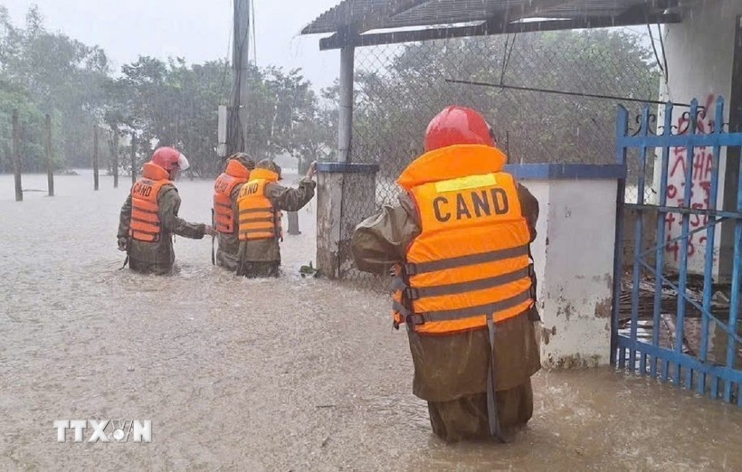 Lực lượng Công an hỗ trợ di dời người dân vùng ngập sâu đến nơi an toàn. Ảnh: TTXVN.