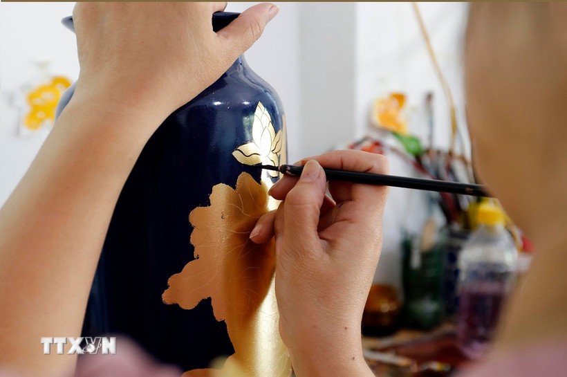 Vẽ hoa văn trên sản phẩm gốm sứ tại làng nghề Hạ Thái. Ảnh: Trần Việt/TTXVN.
