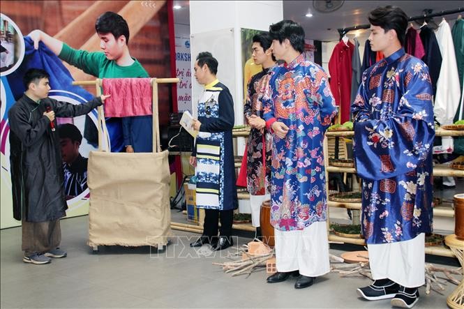 Nhà thiết kế Nguyễn Đức Huy, Thương hiệu cổ phục Đông Phong (áo dài đen), trình diễn khâu nhuộm màu bằng chất liệu tự nhiên bản địa độc đáo sử dụng trong thiết kế bộ sưu tập áo dài "Nếp màu tự nhiên". 