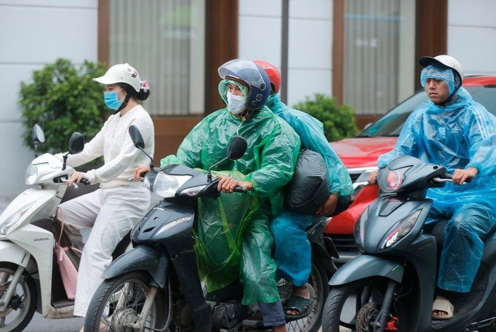 Nhiều người phải mặc áo mưa giữ ấm.