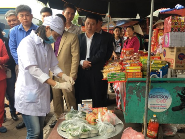 Nhân viên y tế test nhanh sản phẩm giò tại cổng đền Trần. Ảnh: Lê Nga.