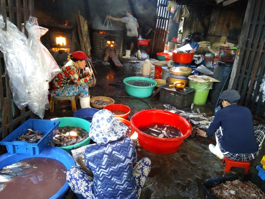 Những người thợ hấp cá ăn vội buổi sáng ngay tại lò hấp. Ảnh: Vân Phi